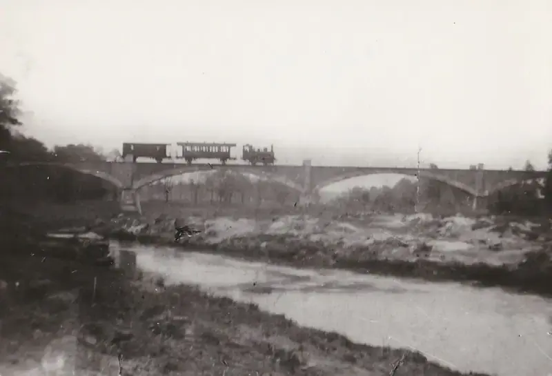 Historischer Zug der Kleinbahn Rothenburg auf einer Brücke über einen Fluss in der Oberlausitz